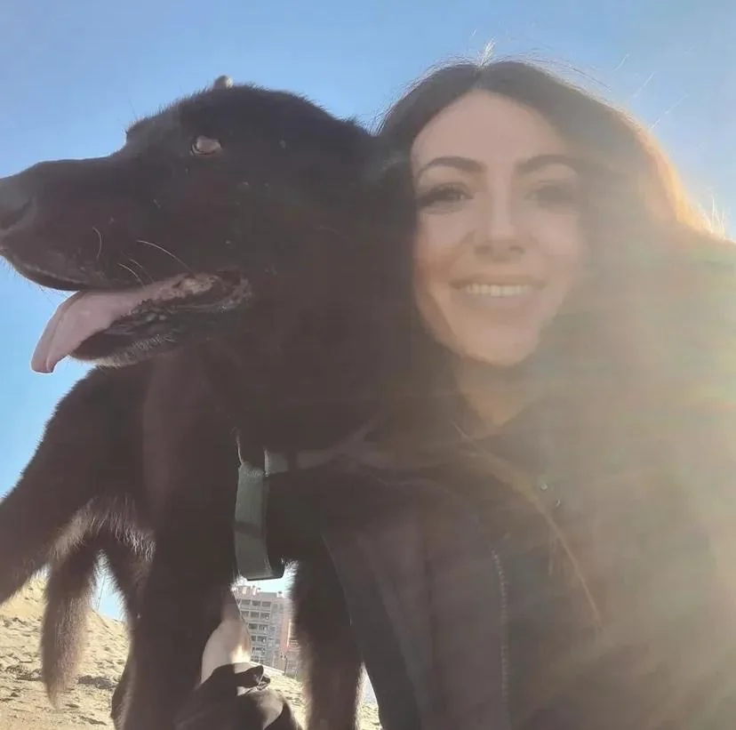 Valentina accanto a un cane nero durante un’attività all’aperto